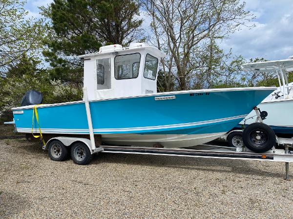 SeaCraft 23 CC 1987 SeaCraft 23 CC boat on trailer, vibrant blue hull, parked outdoors.