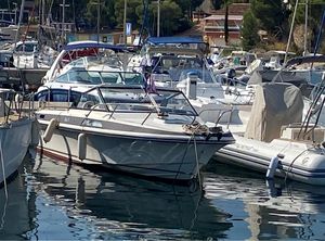 Windy 23 1984 Windy 23 boat docked in a marina, surrounded by other vessels.