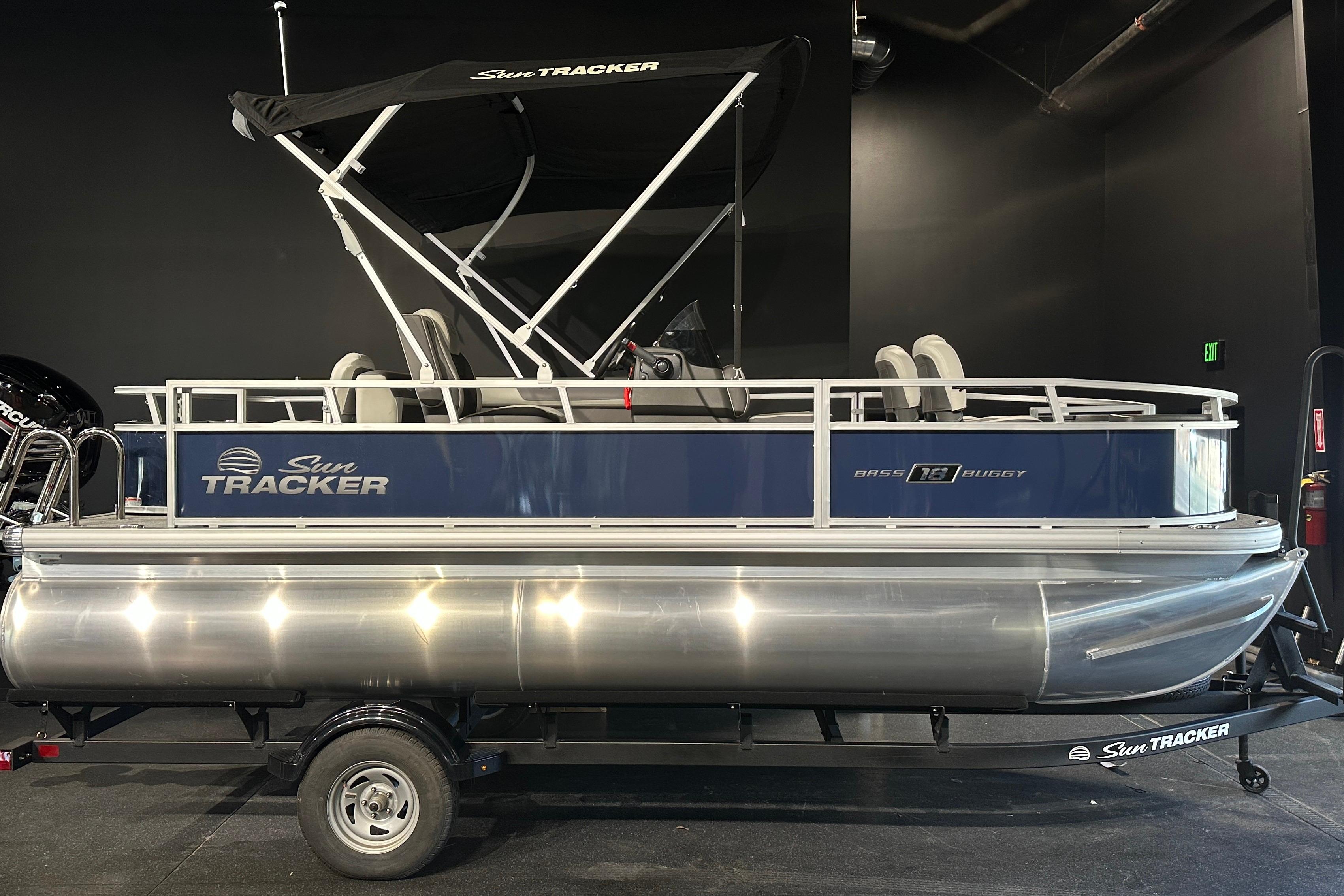 Sun Tracker Bass Buggy 18 DLX 2026 Sun Tracker Bass Buggy 18 DLX pontoon boat with canopy, displayed indoors.