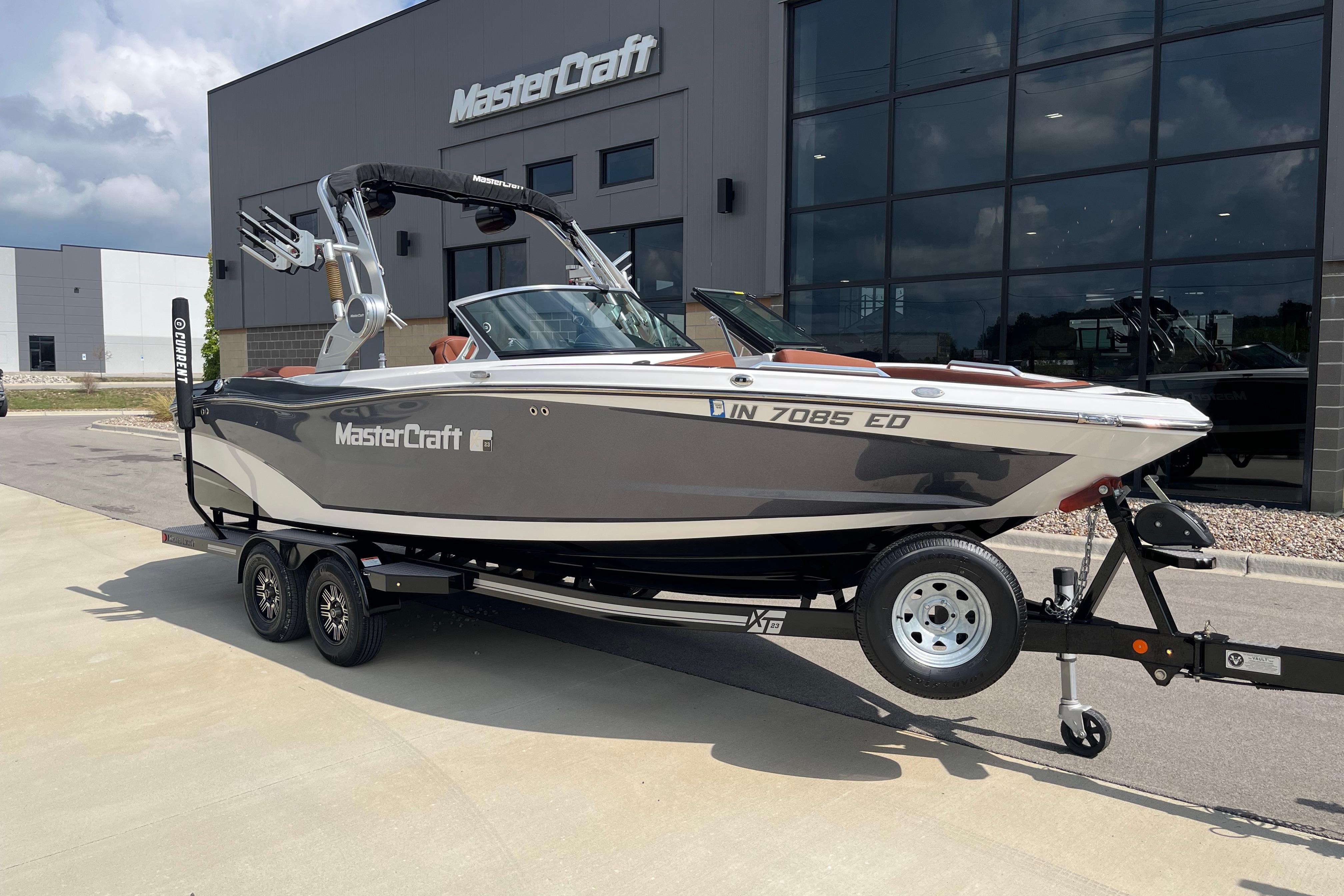 MasterCraft XT23 2020 MasterCraft XT23 boat on trailer outside dealership building.