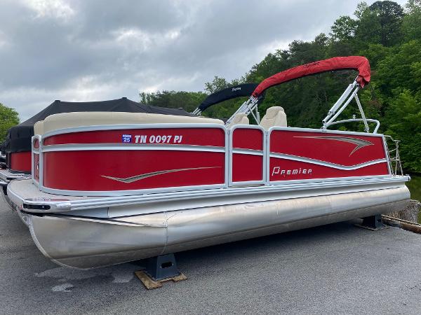 Premier 210 Sunsation RL 2022 Premier 210 Sunsation RL pontoon boat with red exterior, docked on a cloudy day.