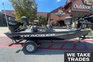 Tracker Pro 170 2026 Tracker Pro 170 boat displayed outside outdoor store, with "We Take Trades" sign.