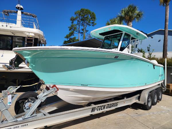 Blackfin 272 CC 2023 Blackfin 272 CC boat on trailer, vibrant turquoise hull, parked outdoors.