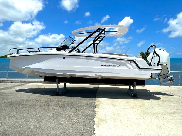 Axopar 25 Cross Top 2024 Axopar 25 Cross Top boat on display by the water under a clear blue sky.