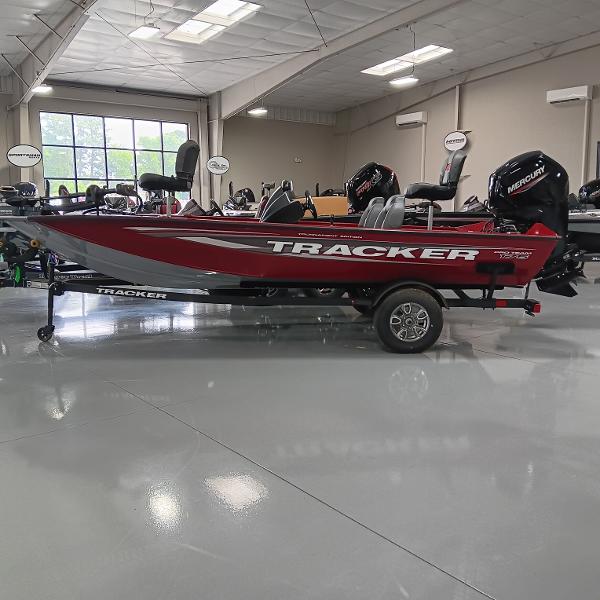 Tracker Pro Team 175 2025 Tracker Pro Team 175 boat in showroom, red and silver design, on trailer.
