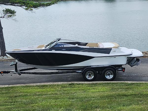 Glastron GT 205 2016 Glastron GT 205 boat on trailer by a lake.