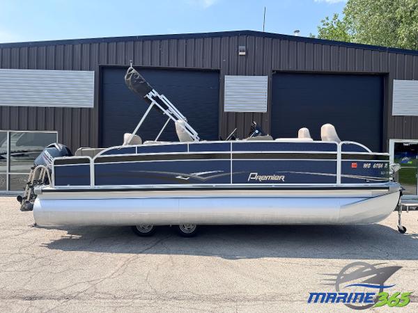 Premier Re 221 Explorer 2013 Premier EXPLORER 221 pontoon boat parked outside a warehouse.