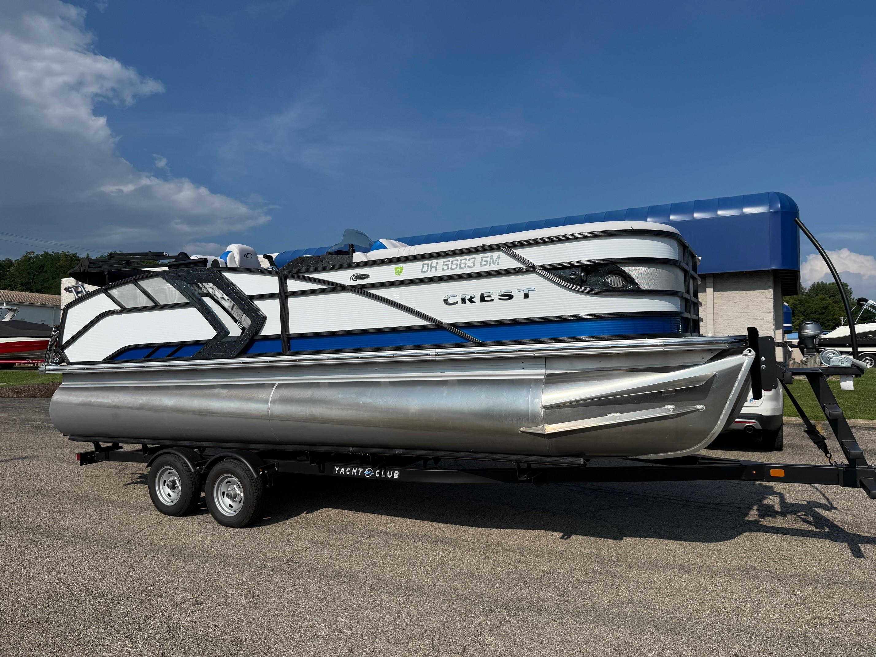 Crest Caribbean RS 230 2023 Crest Caribbean RS 230 pontoon boat on trailer under clear blue sky.