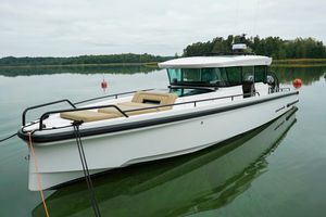 Axopar 37 XC 2021 Axopar 37 XC boat on calm water with lush green shoreline.