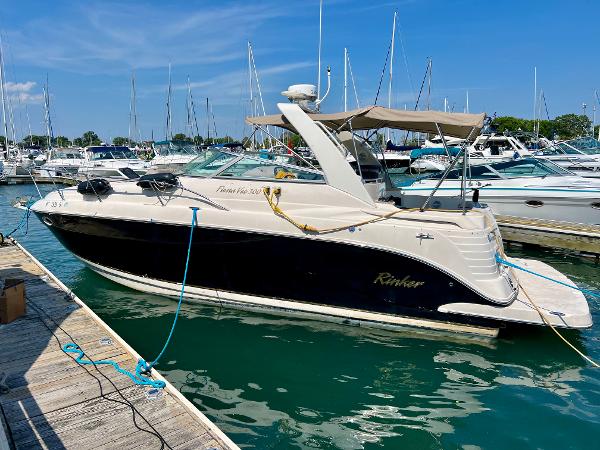 Rinker Fiesta Vee 300 2006 Rinker Fiesta Vee 300 boat docked in a marina under a clear blue sky.