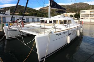 Lagoon 440 2009 Lagoon 440 catamaran docked in a marina, featuring sleek design and spacious deck.