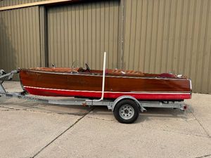 Chris-Craft 18 Runabout 1932 Chris-Craft Runabout 18 wooden boat on trailer, parked outside a building.