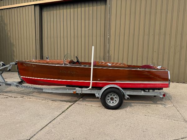 Chris-Craft Runabout 18 1932 Chris-Craft Runabout 18 wooden boat on trailer, parked outside a building.