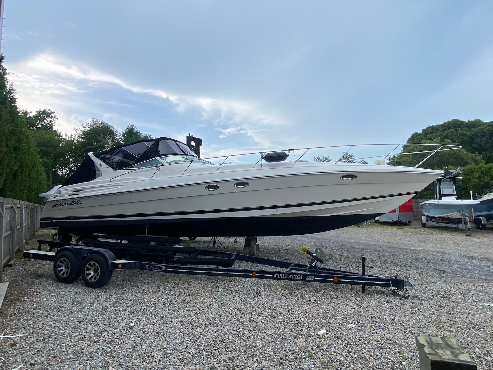 Wellcraft 45 Excalibur 2001 Wellcraft 45 Excalibur boat on trailer, parked outdoors on gravel.