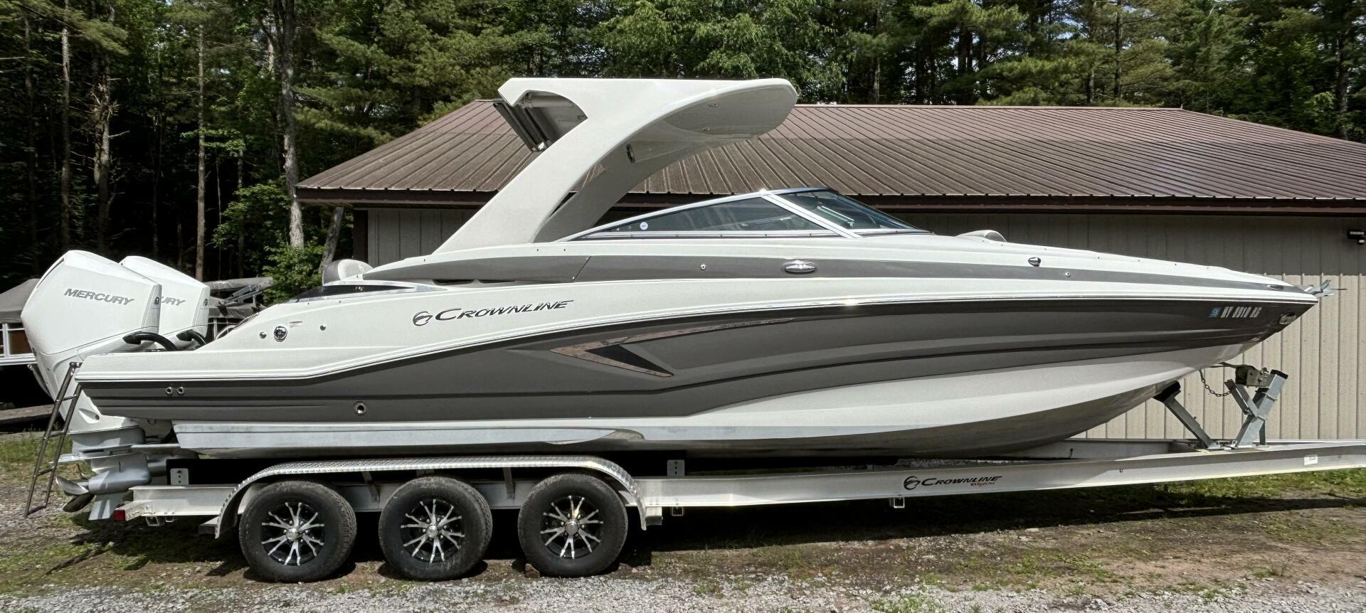 Crownline E305XS 2021 Crownline E305XS boat on trailer, parked outdoors near a building.