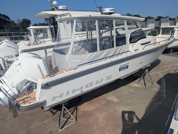 Nimbus Tender 9 2025 Nimbus Tender 9 boat with enclosed cabin, displayed on stands in a marina.