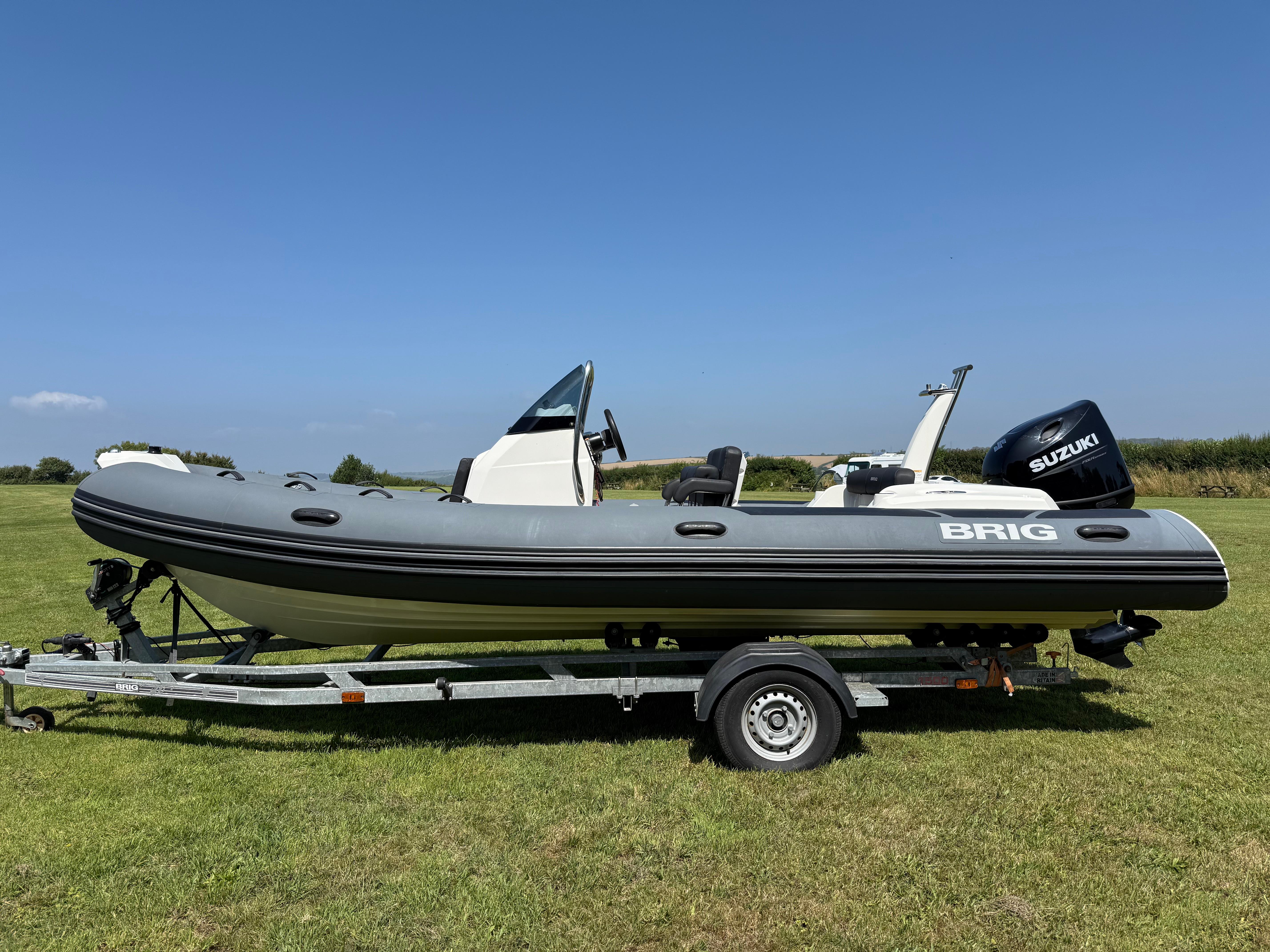 Brig Eagle 6H 2022 Brig Eagle 6H boat on trailer, grassy field, clear blue sky.