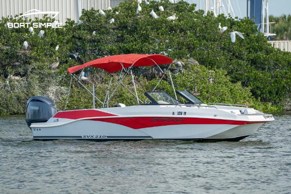 Starcraft SVX 210 OB DC 2024 Starcraft SVX 210 OB DC boat with red canopy on water.