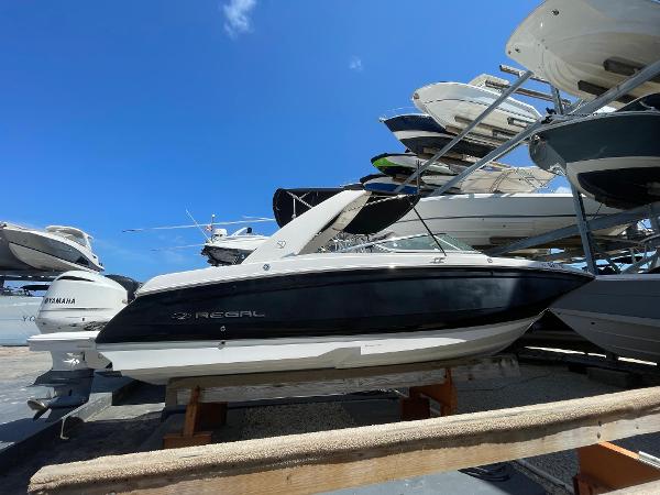 Regal 26 OBX 2021 Regal 260BX boat displayed in a marina under a clear blue sky.