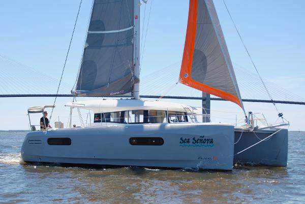 Excess 12 2023 Excess 12 catamaran sailing on open water with bridge in background.