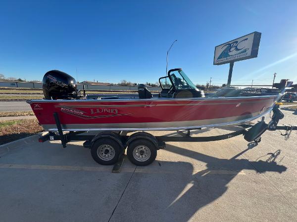Lund 2075 Alaskan Sport 2024 Lund 2075 Alaskan Sport boat on trailer, red exterior, parked outdoors.