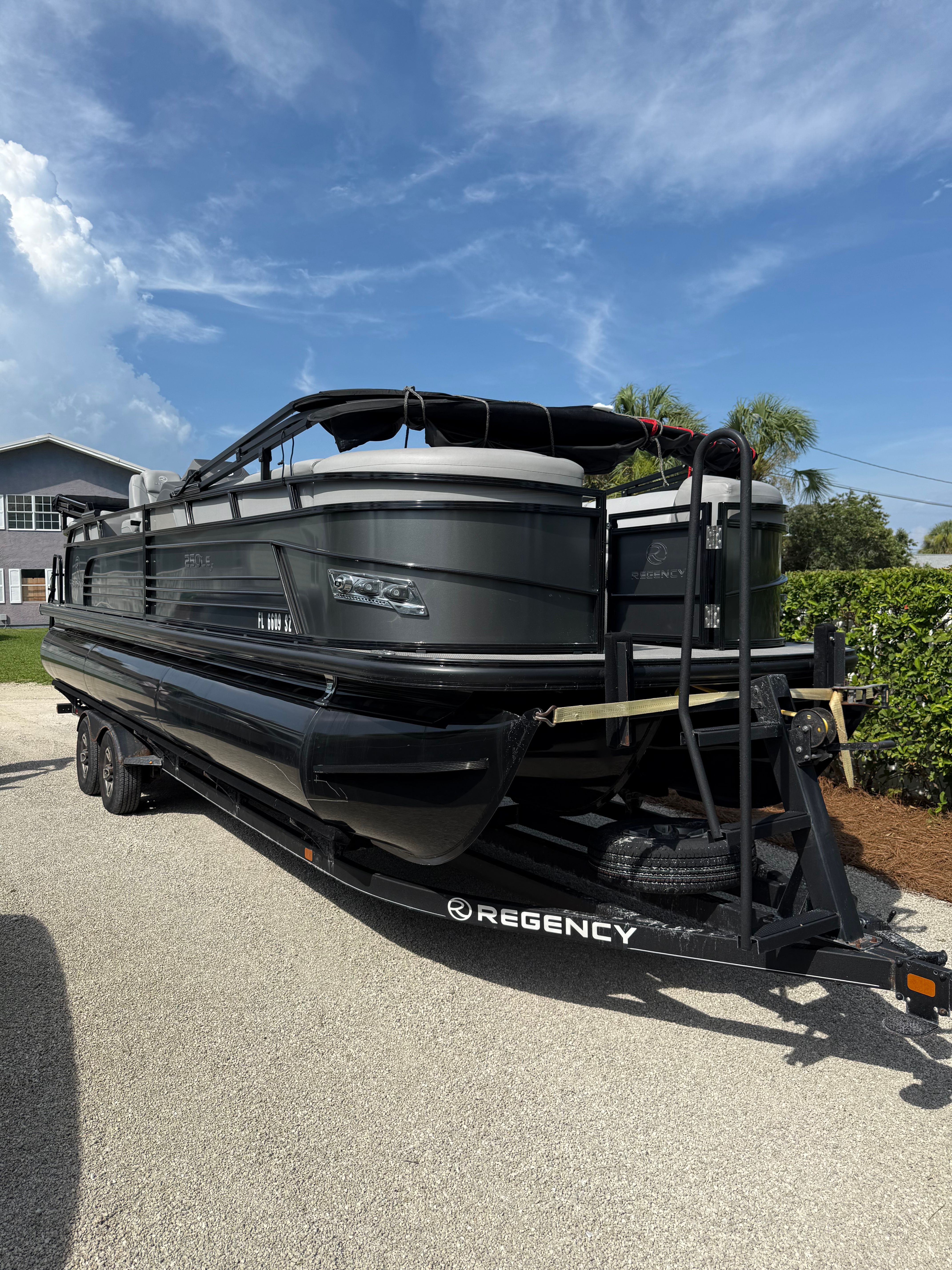 Custom 250le3 Custom 2021 model 250le3 pontoon boat on trailer, sunny day, Regency branding visible.