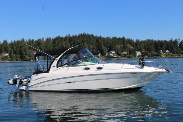 Sea Ray 300 Sundancer 2002 Sea Ray 300 Sundancer boat on calm water with forested shoreline background.