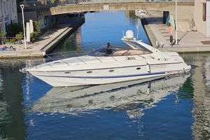 Sunseeker Camargue 47 1997 Sunseeker Camargue 47 yacht cruising in a narrow canal under a bridge.