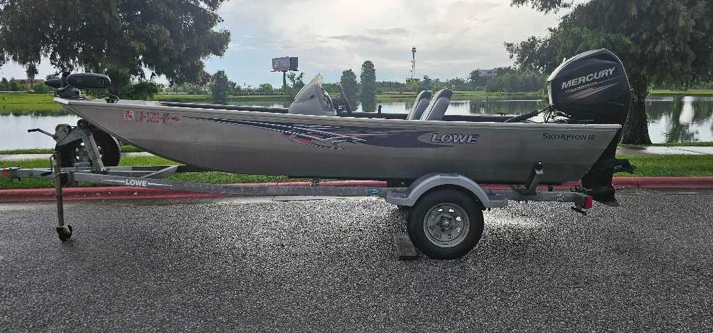 Lowe Stryker 16 2016 Lowe Stryker 16 boat on trailer, parked by a scenic lake.