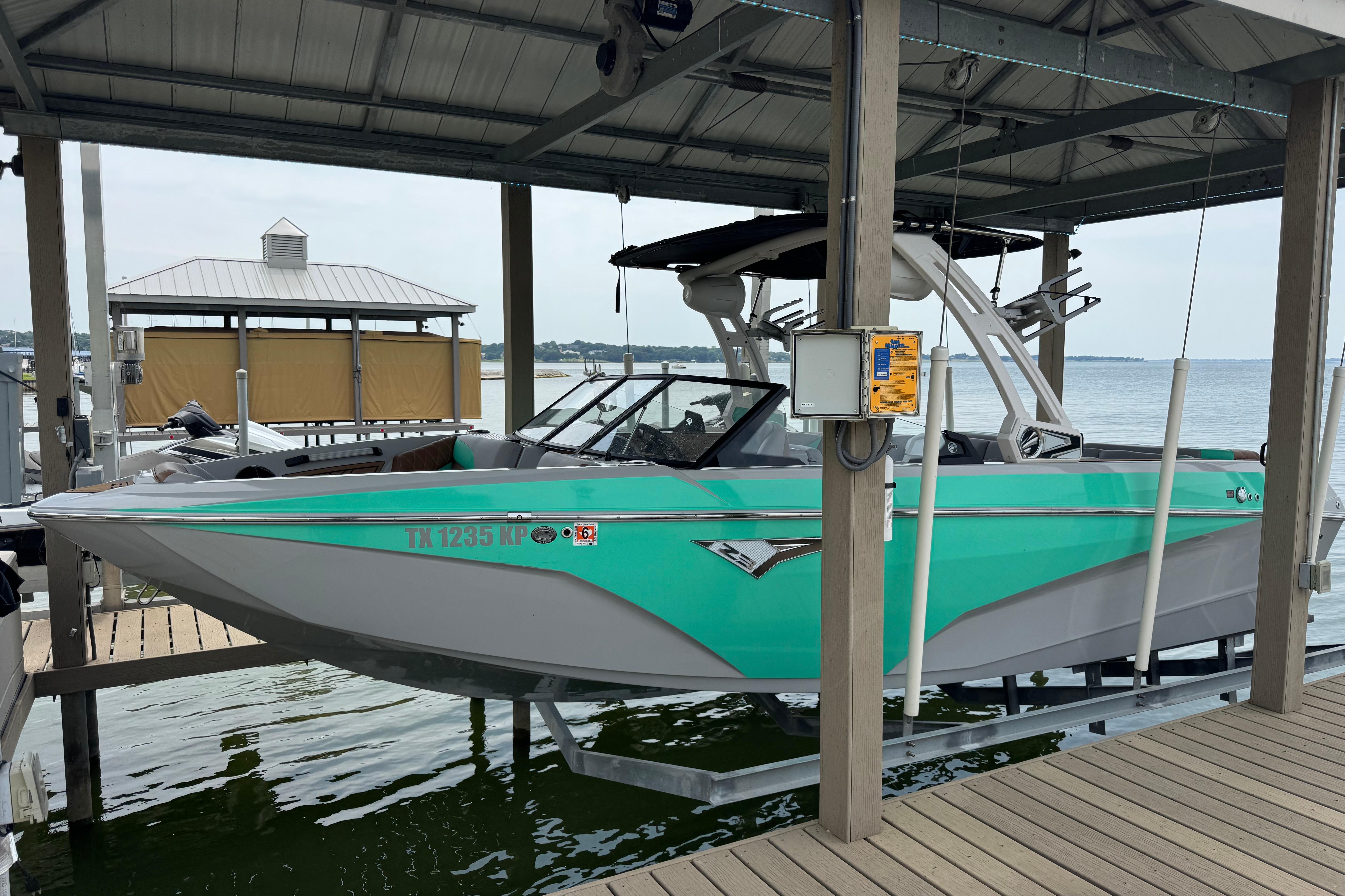 Tigé Z3 2022 Tigé Z3 boat in turquoise, docked on a lift by the lake.