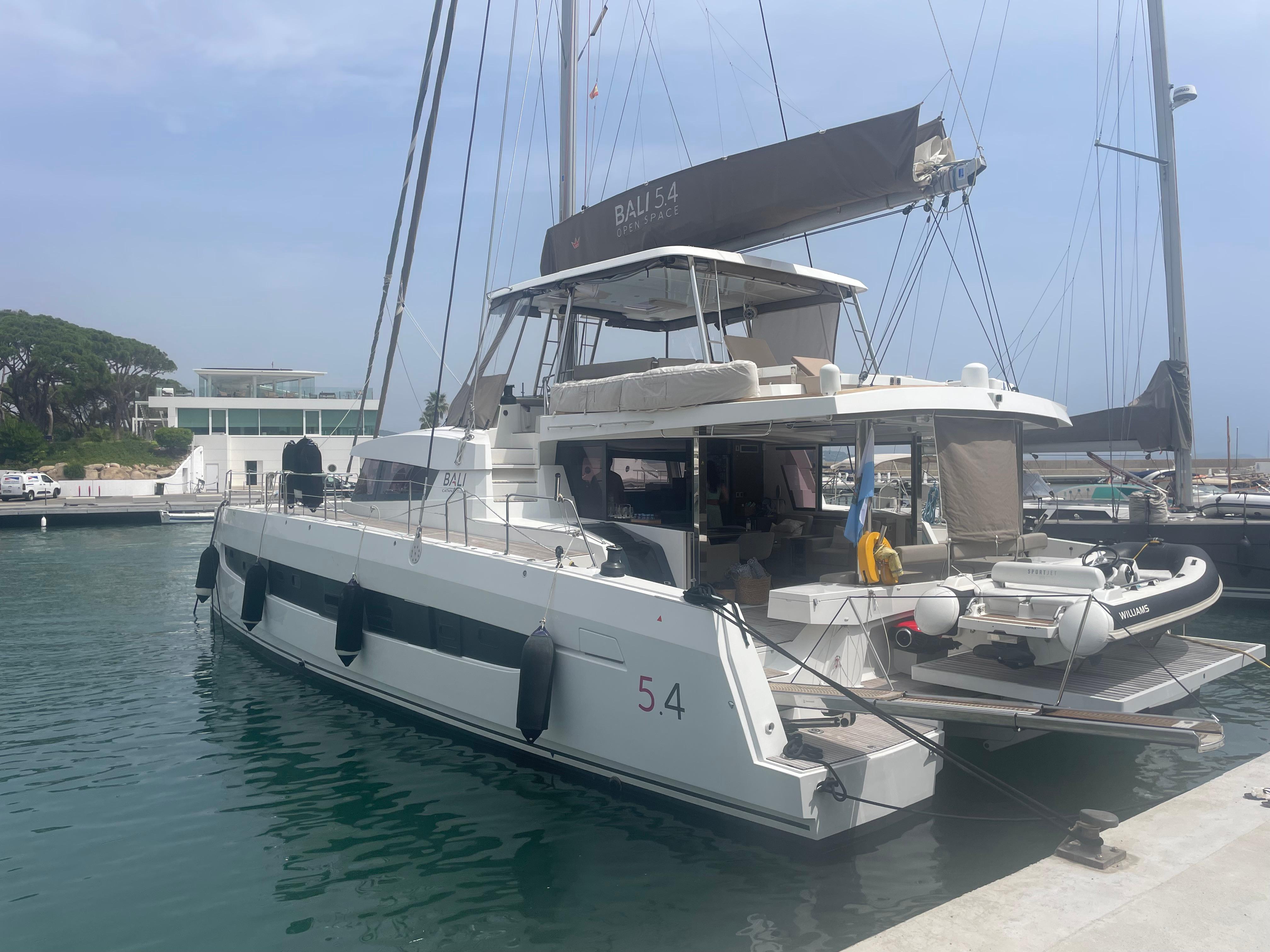 Bali 5.4 Luxury Bali 5.4 catamaran docked at marina, 2023 model, featuring spacious deck and modern design.