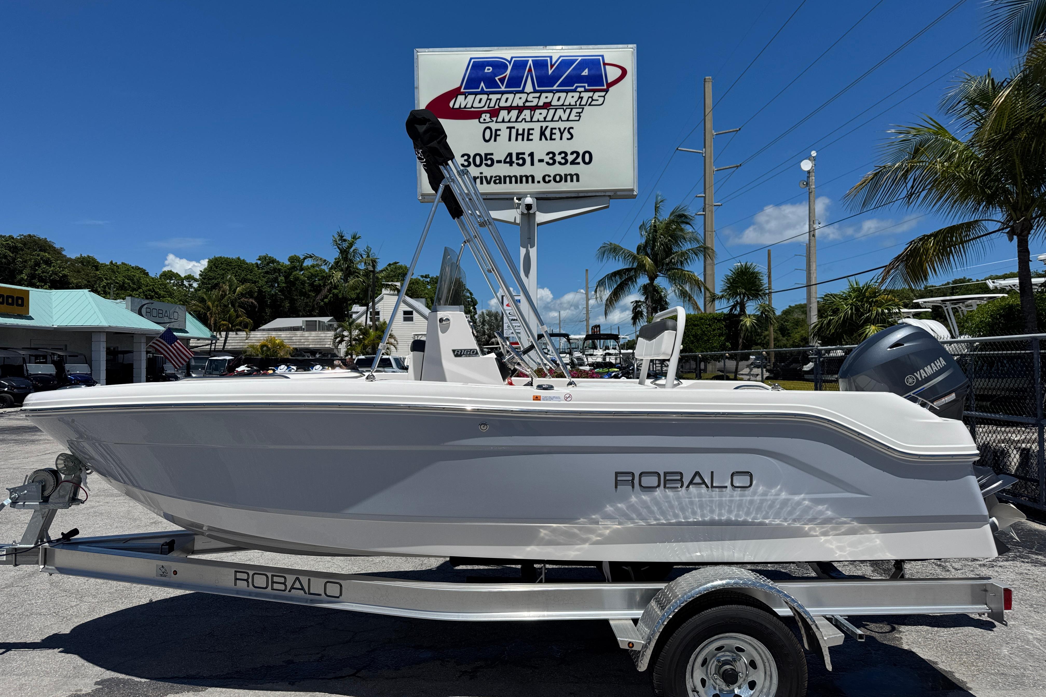 Robalo R160 Center Console 2025 Robalo R160 Center Console boat on trailer at dealership, sunny day.