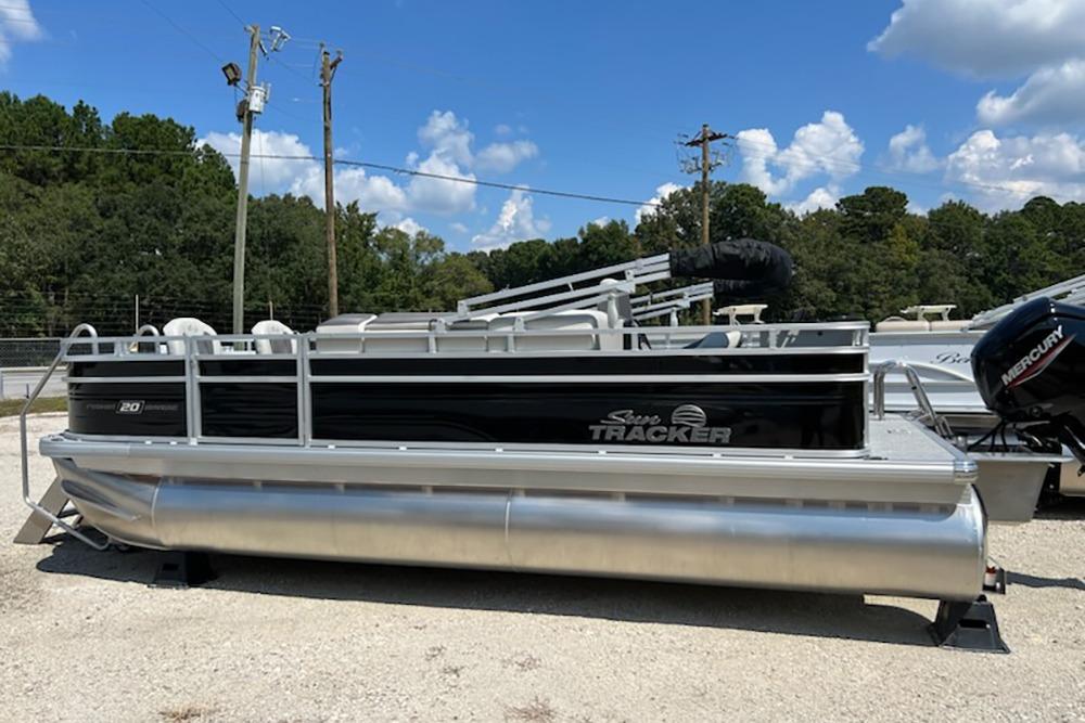 Sun Tracker Fishin' Barge 20 DLX 2026 Sun Tracker Fishin' Barge 20 DLX pontoon boat on display outdoors.