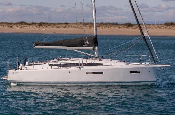 Jeanneau Sun Odyssey 380 2022 Jeanneau Sun Odyssey 380 sailboat on calm water near sandy shore.