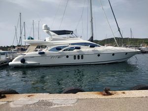 Azimut 62 Luxury 2005 Azimut 62 yacht docked in a marina, surrounded by sailboats.