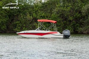Starcraft SVX 190 OB 2024 Starcraft SVX 190 OB DC boat with red canopy on a calm lake.