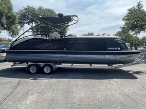 Bennington 2575 QCW I/O Sport Arch 2015 Bennington 25 IO QCW pontoon boat on a trailer in a parking lot.