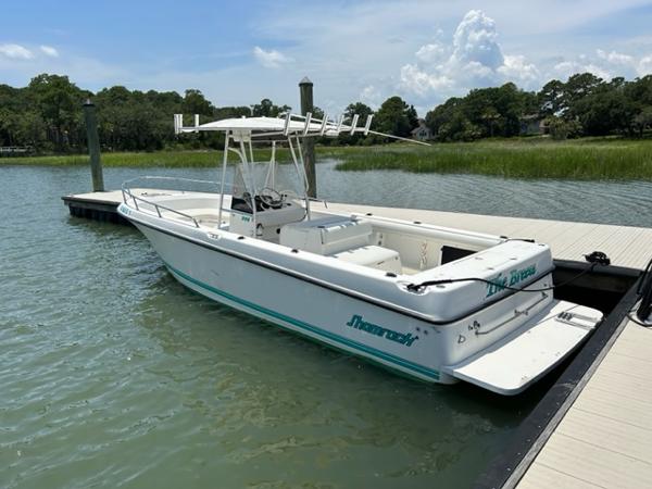 Shamrock Center Console 2000 Shamrock Center Console boat docked on a calm lake.