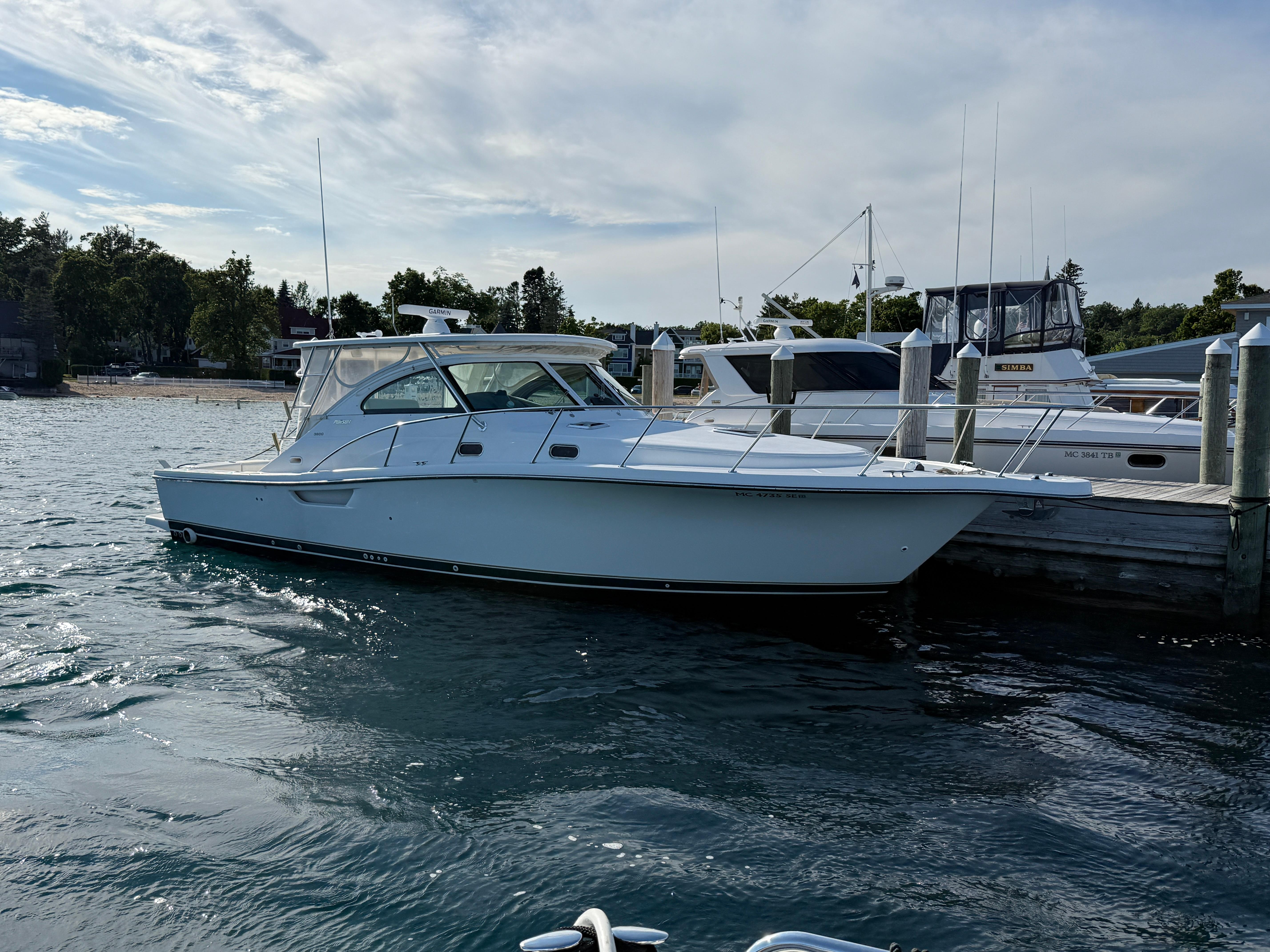 Pursuit 3800 Express 2002 Pursuit 3800 Express boat docked at marina, calm water, partly cloudy sky.