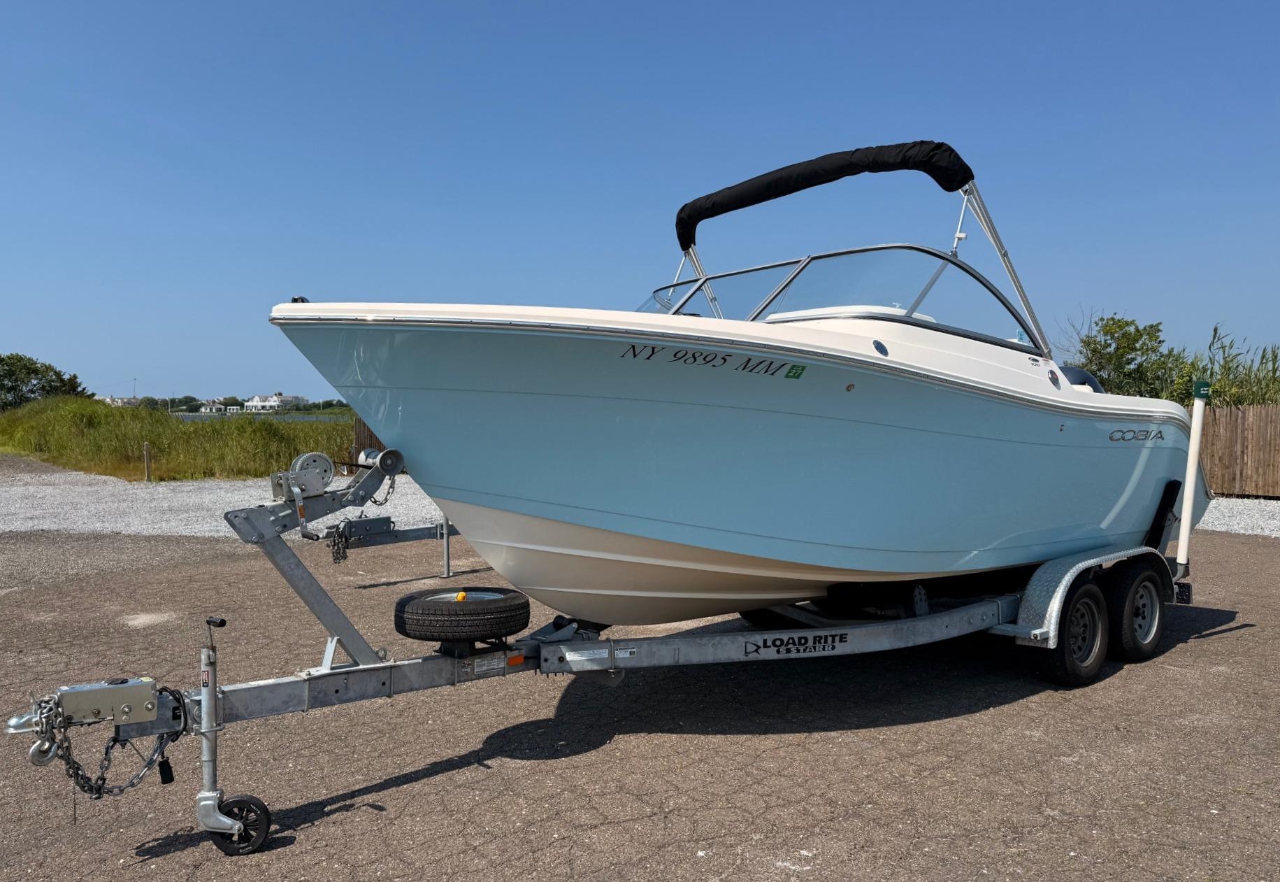 Cobia 220 Dual Console 2017 Cobia 220 Dual Console boat on trailer, parked outdoors under clear blue sky.