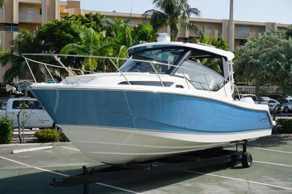 Boston Whaler 325 Conquest 2023 Boston Whaler 325 Conquest boat on trailer in parking lot.
