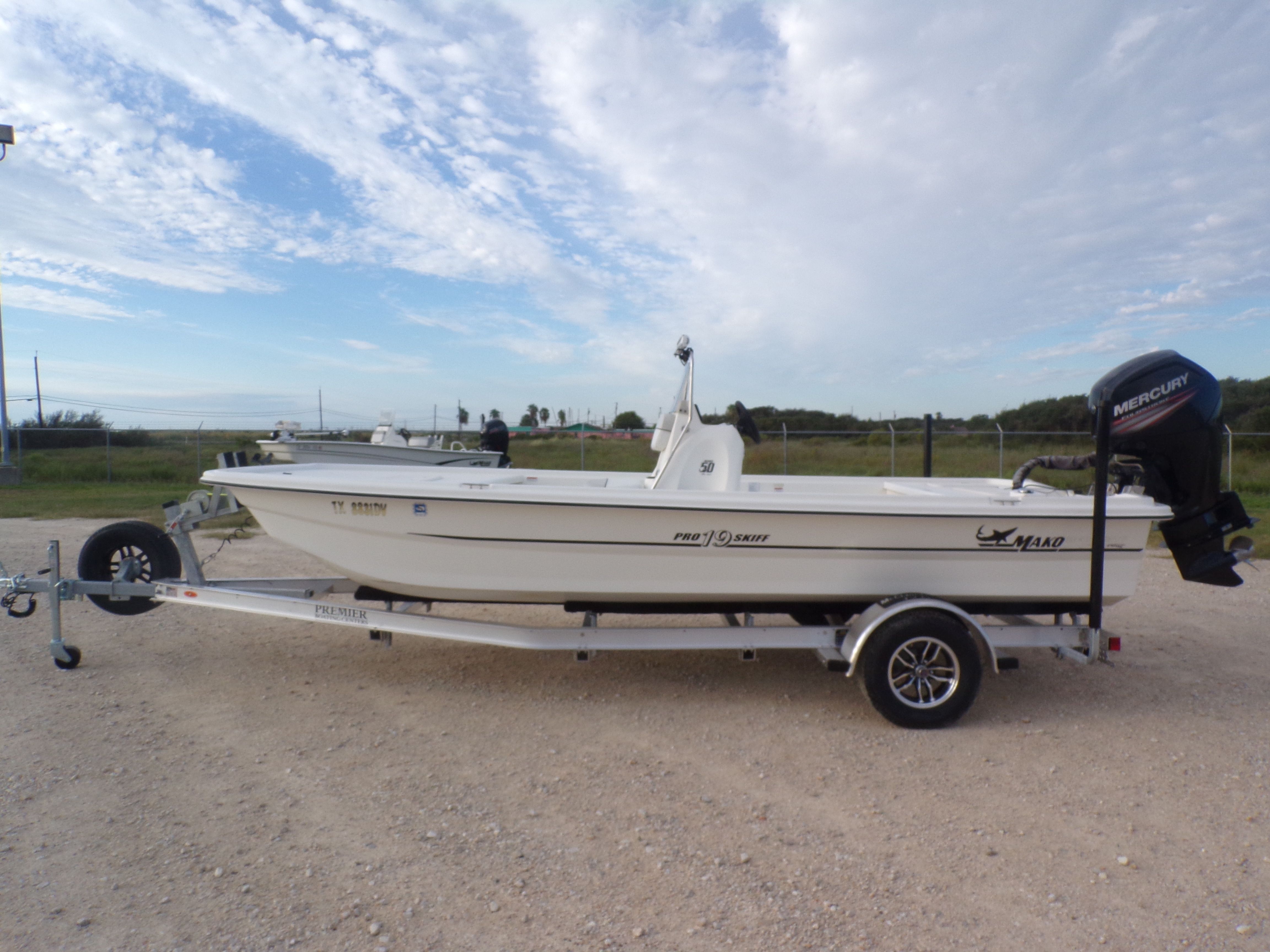 Mako Pro Skiff 19 CC 2017 Mako Pro Skiff 19 CC boat on trailer, outdoors under a cloudy sky.
