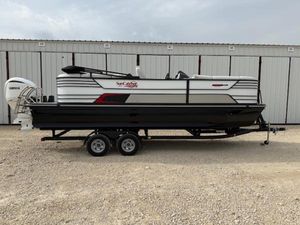 SunCatcher Elite 324 RC 2025 SunCatcher Elite 324 RC pontoon boat on trailer, parked outdoors.