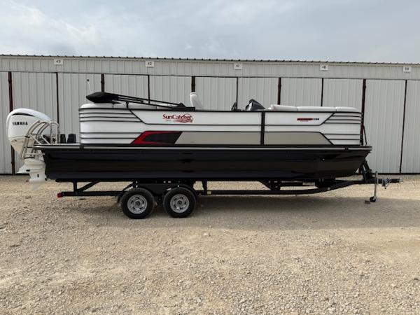SunCatcher Elite 324 RC 2025 SunCatcher Elite 324 RC pontoon boat on trailer, parked outdoors.