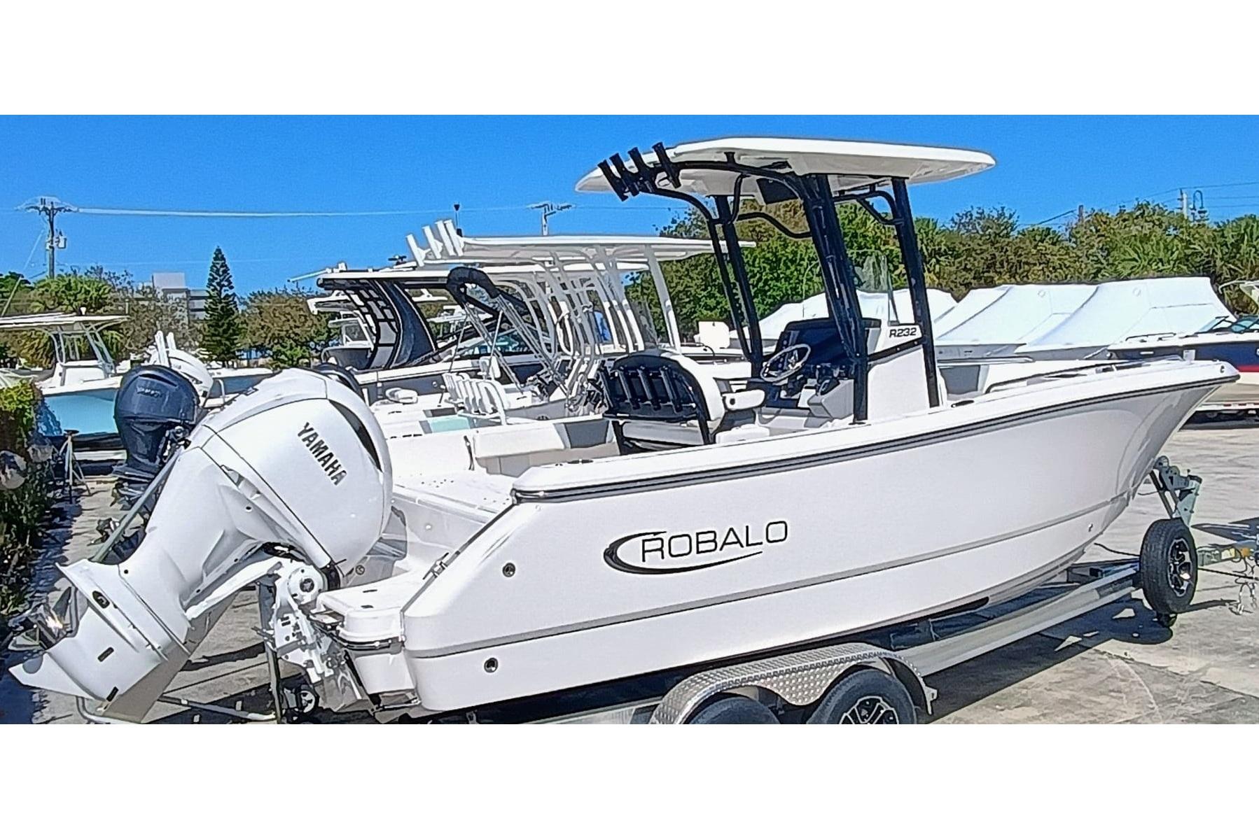 Robalo R232 Explorer 2025 Robalo R232 Explorer boat with Yamaha engine on trailer, parked outdoors.