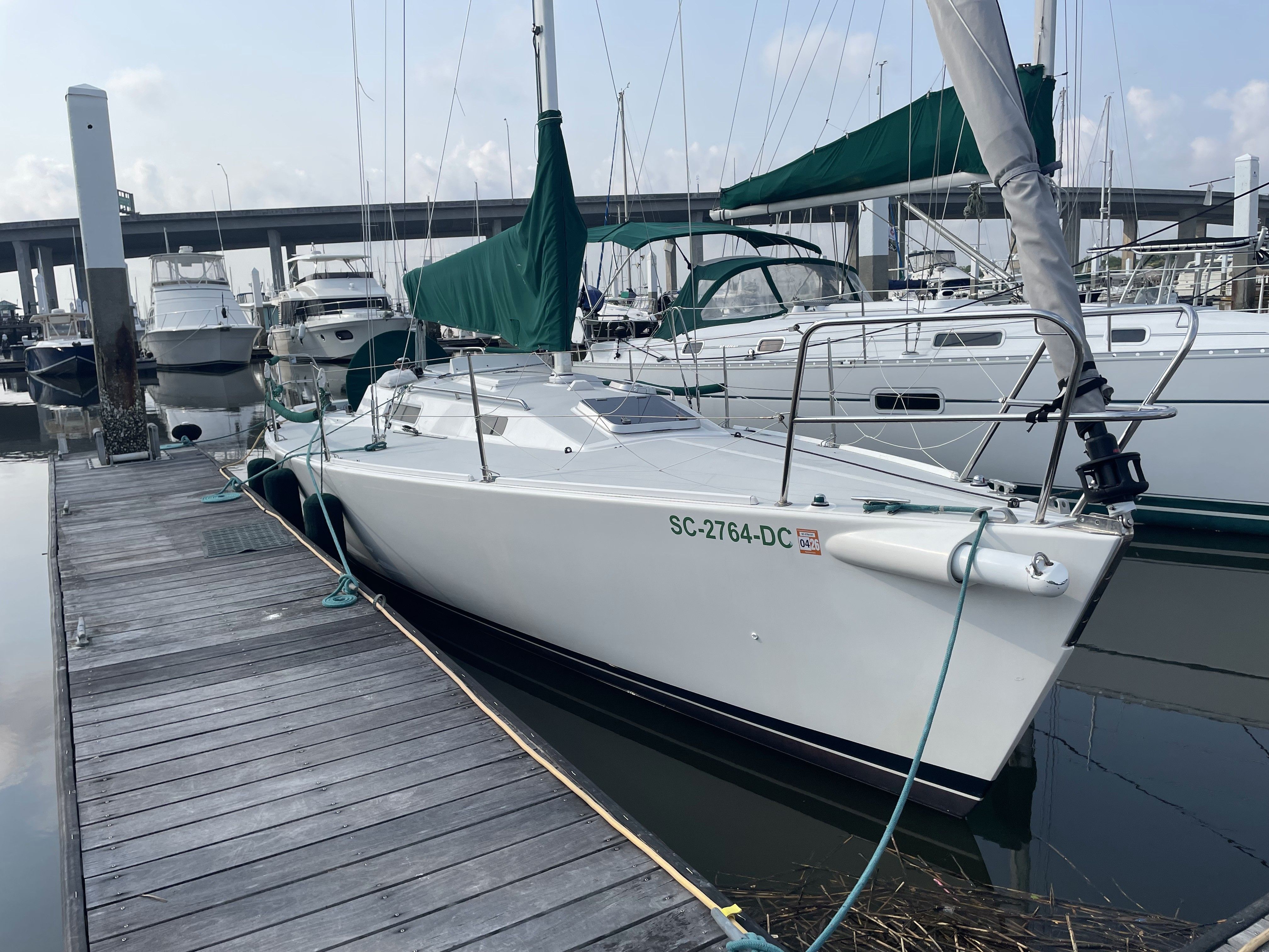 J Boats J/105 2000 J Boats J/105 sailboat docked at marina with green covers.