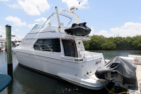 Carver 450 Voyager Pilothouse 1999 Carver 450 Voyager Pilothouse yacht docked at marina, clear sky background.