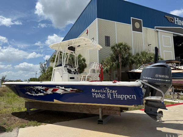 NauticStar 244 XTS 2015 NauticStar 244 XTS boat with Yamaha engine, parked near a warehouse under a blue sky.