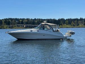 Sea Ray 340 Sundancer 2004 Sea Ray 340 Sundancer boat on a calm lake with forested shoreline.