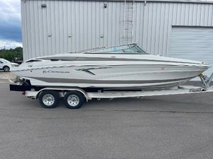 Crownline 240 SS 2023 Crownline 240SS boat on trailer, parked outside a warehouse.